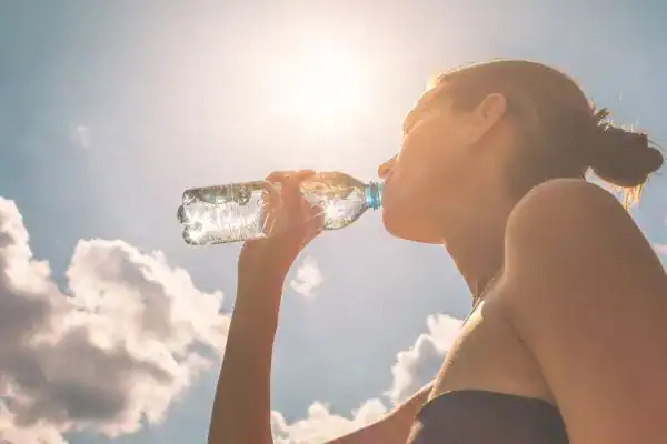 Hydration: The Secret Ingredient for a Toned Stomach and Enhanced Fitness 3 Image of woman drinking water to hydrate Swindon after run.